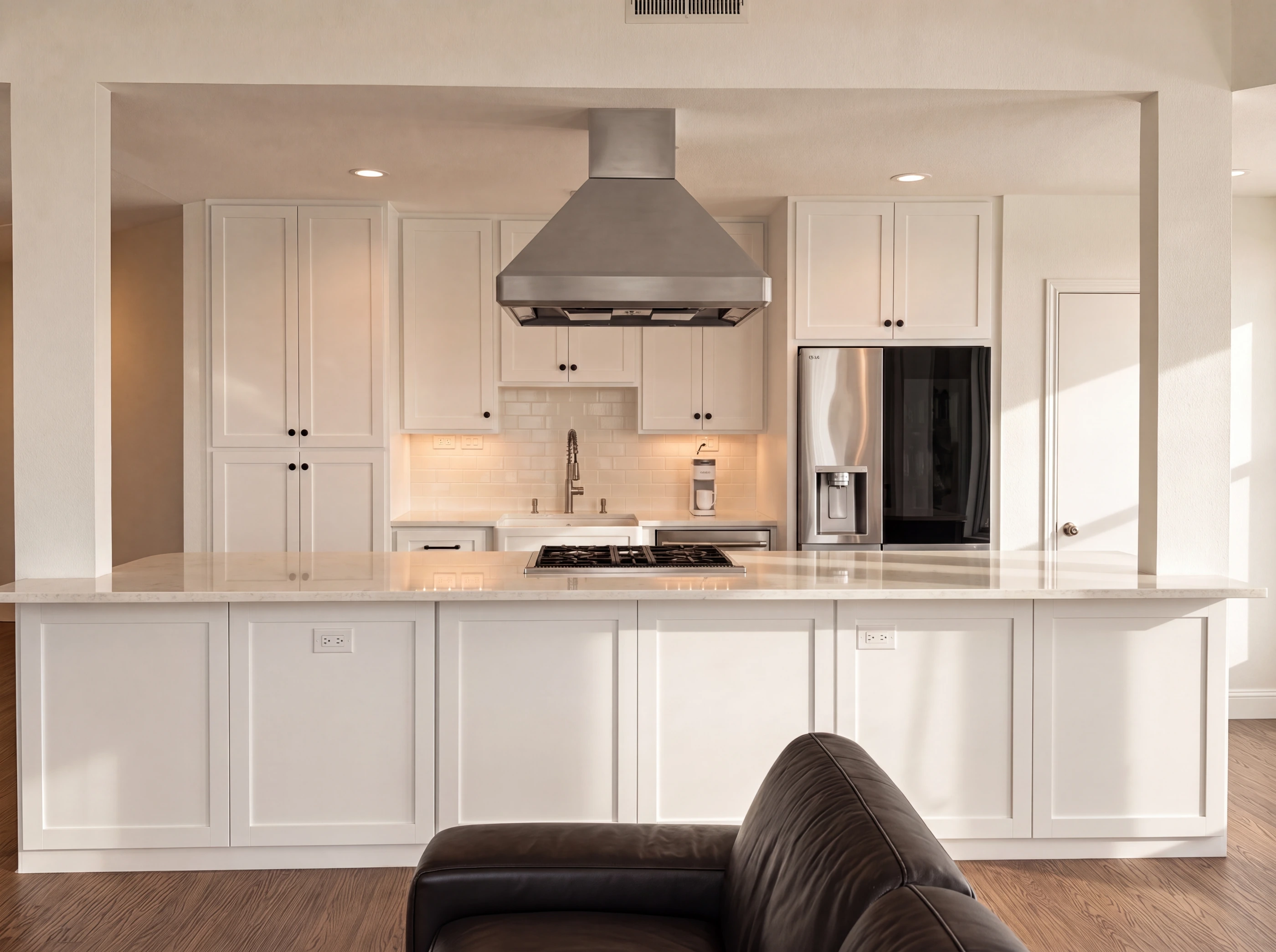 Kitchen with quartz counters, gas cooktop and stainless hood